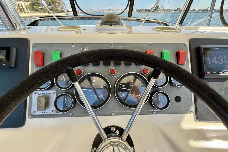 Seafood (reserved) Yacht Photos Pics Steering wheel and dashboard of 1998 Riviera 43 Open Flybridge yacht, featuring gauges and controls.