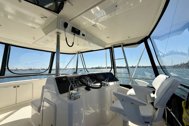 Seafood (reserved) Yacht Photos Pics Interior view of 1998 Riviera 43 Open Flybridge yacht with helm and ocean backdrop.