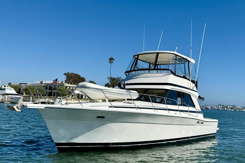 Seafood (reserved) Yacht Photos Pics 1998 Riviera 43 Open Flybridge yacht on calm water under clear blue sky.