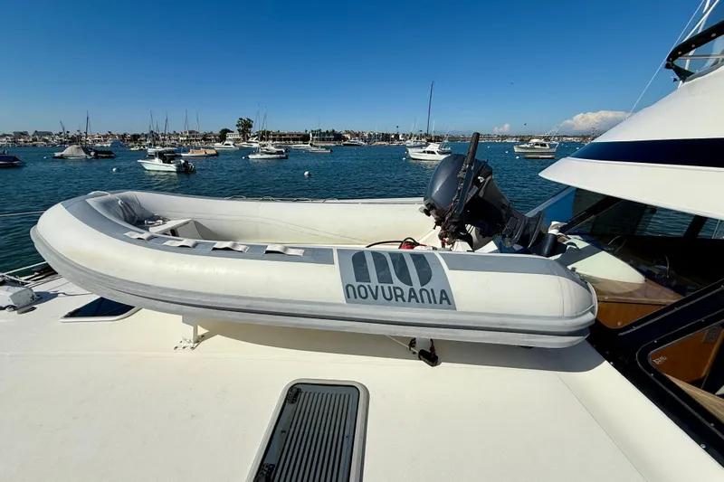 Seafood (reserved) Yacht Photos Pics Riviera 43 Open Flybridge 1998 with Novurania tender on deck, moored in a scenic harbor.