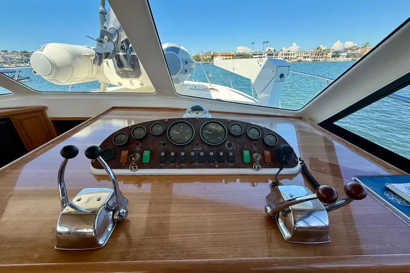 Seafood (reserved) Yacht Photos Pics 1998 Riviera 43 Open Flybridge helm with controls and gauges, overlooking marina view.