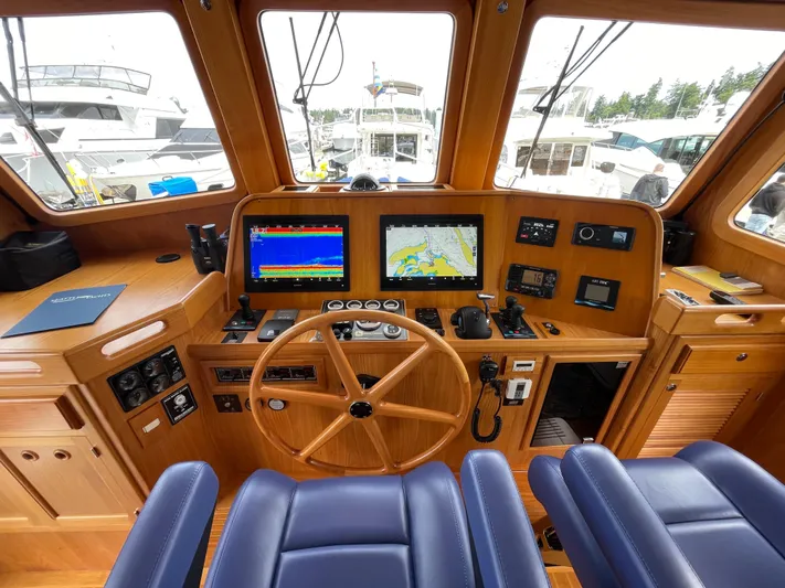 Sherlock Holmes Yacht Photos Pics Kadey-Krogen 44E 2016 helm with navigation screens and wooden steering wheel.