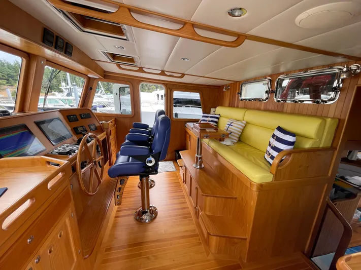 Sherlock Holmes Yacht Photos Pics Luxurious 2016 Kadey-Krogen 44E yacht interior with wooden finish, blue chairs, and yellow seating.