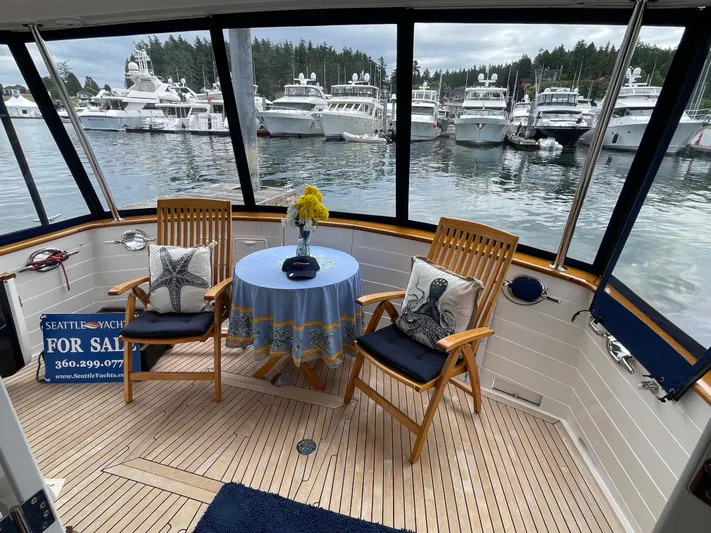 Sherlock Holmes Yacht Photos Pics Cozy deck of 2016 Kadey-Krogen 44E yacht with chairs, table, and marina view.