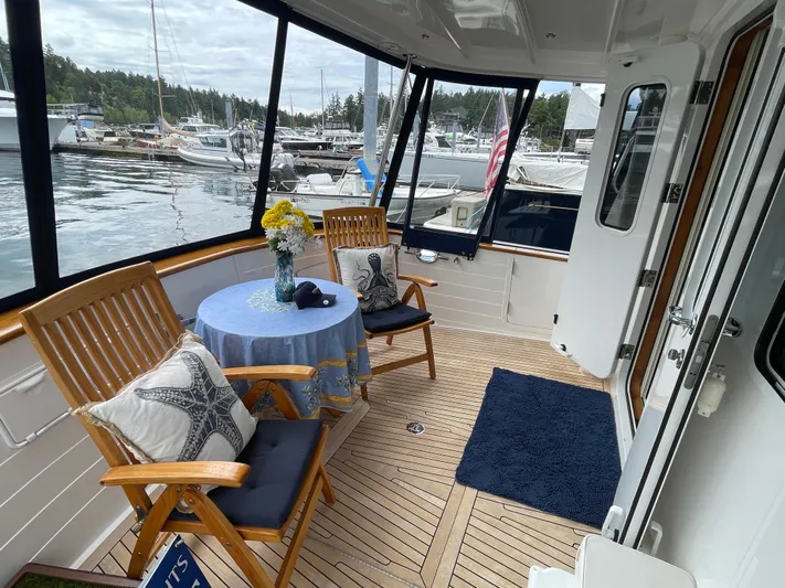 Sherlock Holmes Yacht Photos Pics Kadey-Krogen 44E yacht deck with table, chairs, and marina view, 2016 model.