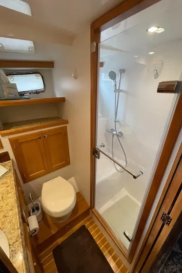 Sherlock Holmes Yacht Photos Pics Kadey-Krogen 44E 2016 yacht bathroom with shower, toilet, and wooden cabinetry.
