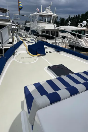 Sherlock Holmes Yacht Photos Pics Kadey-Krogen 44E 2016 yacht deck with striped seating, docked at marina.