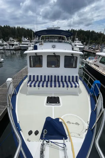 Sherlock Holmes Yacht Photos Pics Kadey-Krogen 44E yacht, 2016 model, docked at marina with striped seating and overcast sky.