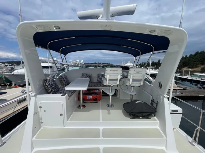 Sherlock Holmes Yacht Photos Pics 2016 Kadey-Krogen 44E yacht deck with seating, table, and canopy at marina.