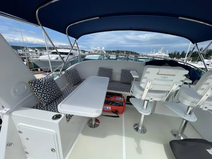 Sherlock Holmes Yacht Photos Pics Flybridge of 2016 Kadey-Krogen 44E yacht with seating and table, docked at marina.