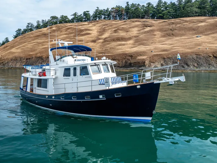 Sherlock Holmes Yacht Photos Pics Kadey-Krogen 44E 2016 yacht on calm water near a rocky shoreline.