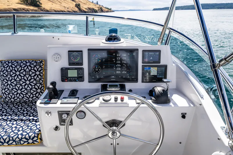 Sherlock Holmes Yacht Photos Pics Helm of 2016 Kadey-Krogen 44E yacht with navigation instruments and patterned seating.