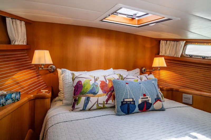 Sherlock Holmes Yacht Photos Pics Cozy bedroom in 2016 Kadey-Krogen 44E yacht with colorful pillows and wooden paneling.
