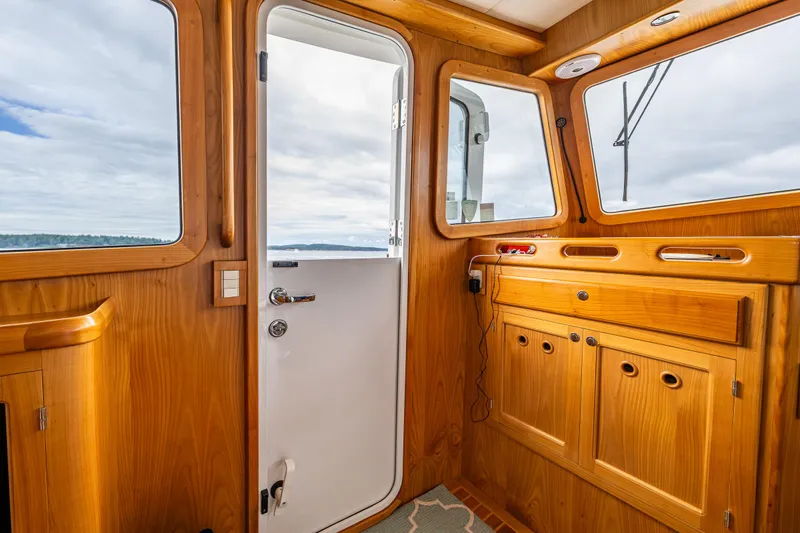 Sherlock Holmes Yacht Photos Pics Interior of 2016 Kadey-Krogen 44E yacht with wooden cabinetry and open door to ocean view.
