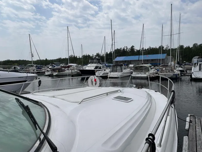  Yacht Photos Pics 2001 Sea Ray 410 Express Cruiser docked at a marina with sailboats in the background.