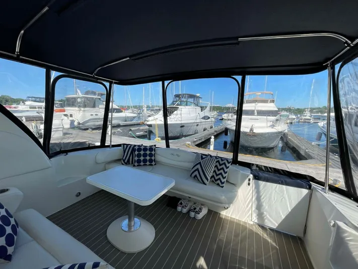  Yacht Photos Pics 2001 Sea Ray 410 Express Cruiser interior with marina view, featuring seating and table.