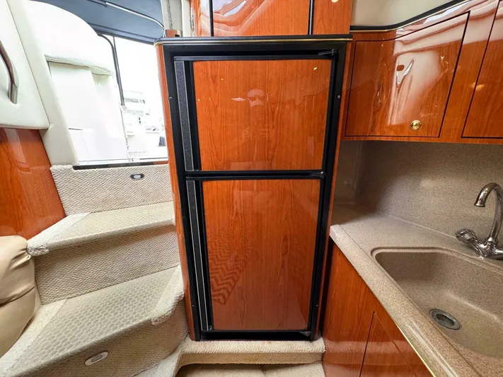  Yacht Photos Pics 2001 Sea Ray 410 Express Cruiser interior with wood-paneled fridge and compact kitchen area.
