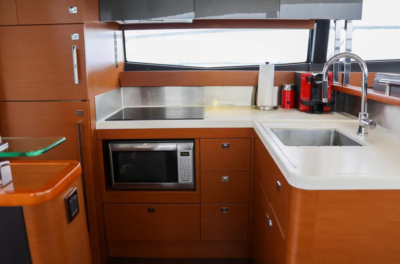  Yacht Photos Pics Modern kitchen in a 2015 Prestige 520 yacht with wood cabinetry and stainless steel appliances.