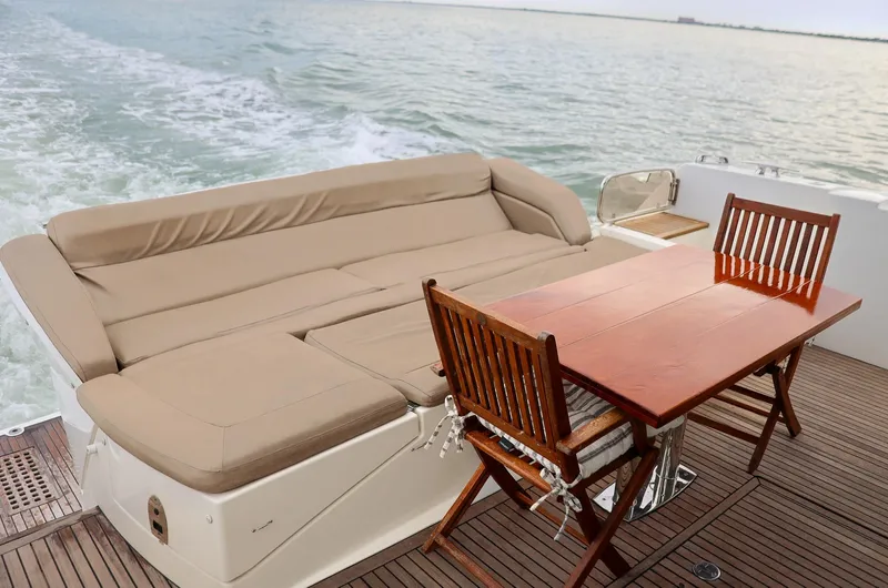  Yacht Photos Pics Luxurious 2015 Prestige 520 yacht deck with seating and dining area on open water.