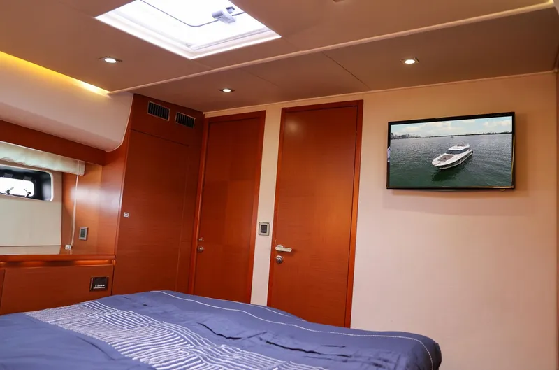  Yacht Photos Pics Luxurious cabin interior of 2015 Prestige 520 yacht with bed and wall-mounted TV.