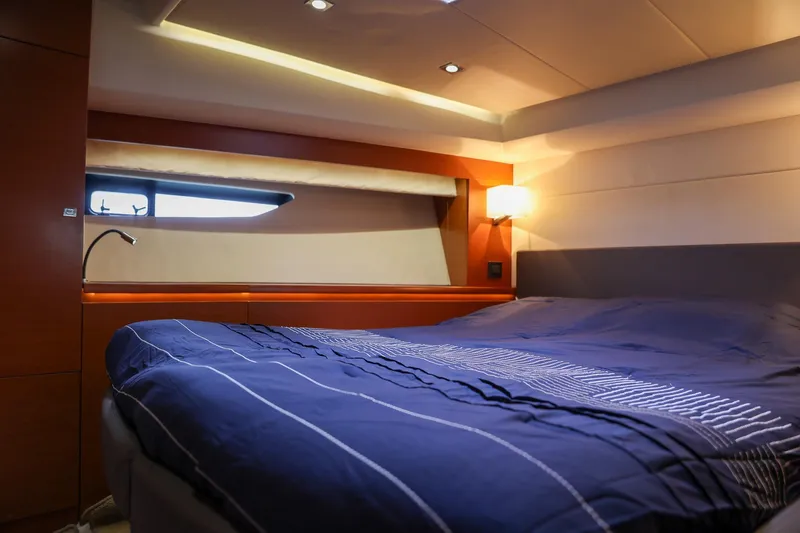  Yacht Photos Pics Luxurious cabin interior of 2015 Prestige 520 yacht with cozy bed and ambient lighting.