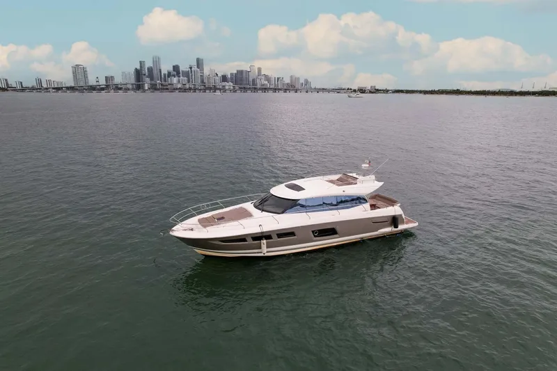  Yacht Photos Pics 2015 Prestige 520 yacht cruising near a city skyline under a partly cloudy sky.
