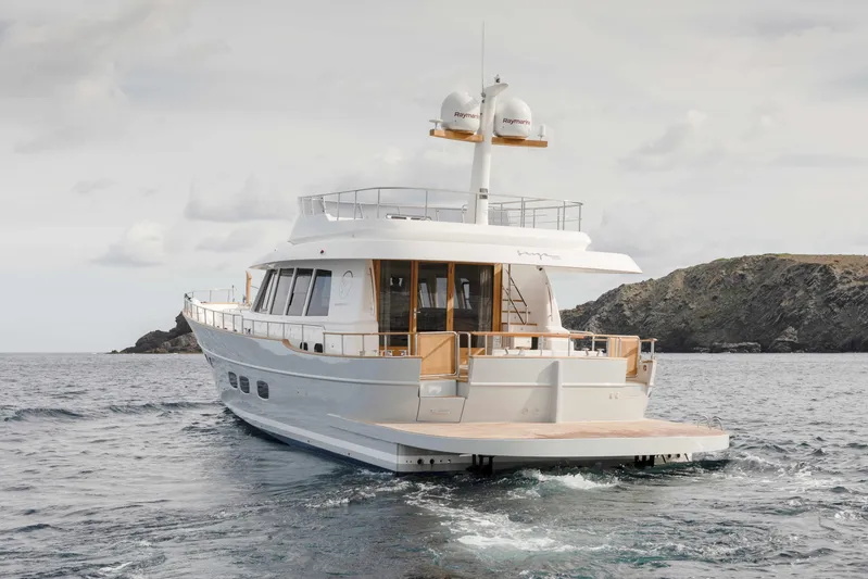  Yacht Photos Pics 2026 Sasga Yachts Menorquin 68 cruising near rocky coastline.