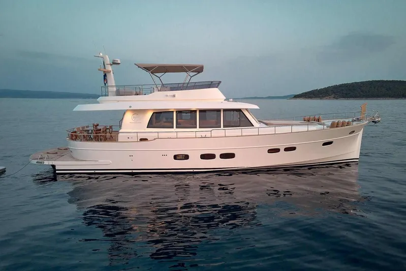  Yacht Photos Pics 2026 Sasga Yachts Menorquin 68 cruising on calm waters at sunset.