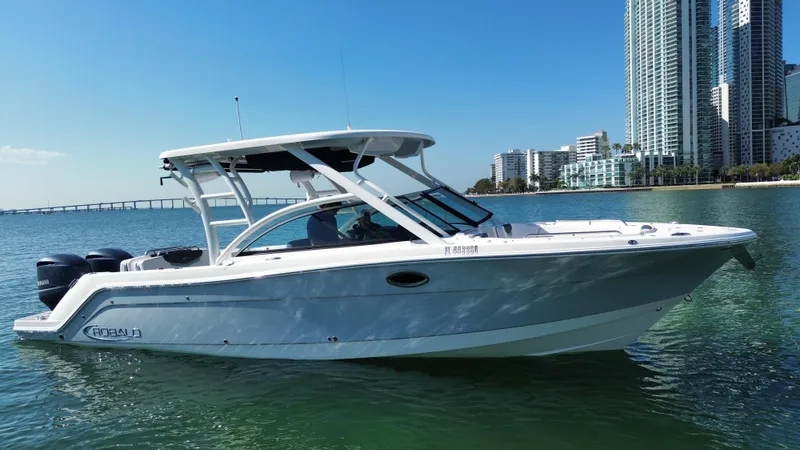  Yacht Photos Pics 2021 Robalo R317 Dual Console boat on water near city skyline.