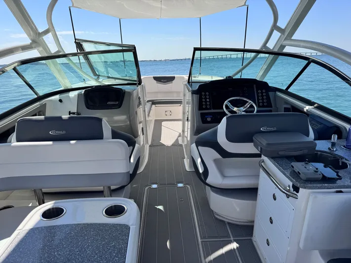  Yacht Photos Pics 2021 Robalo R317 Dual Console boat interior with seating and helm, on calm blue water.