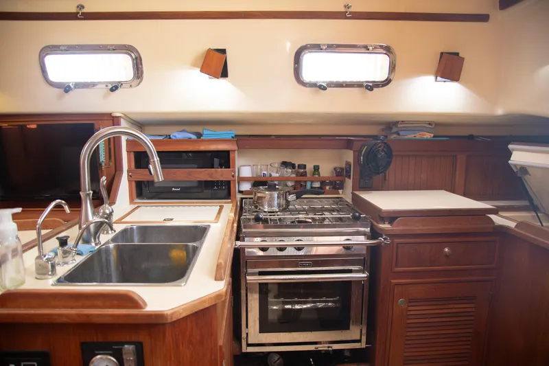 Harvest Moon Yacht Photos Pics Interior of 1999 Island Packet 380 sailboat kitchen with sink, stove, and storage.