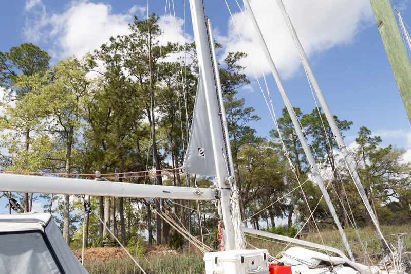 Harvest Moon Yacht Photos Pics Sailboat Island Packet 380, 1999 model, docked near lush trees under a blue sky.
