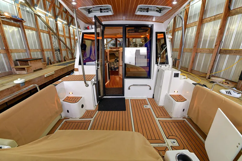 Celtic Mist Yacht Photos Pics 2023 Ranger Tugs R-29S boat interior with wood accents and seating in a docked setting.
