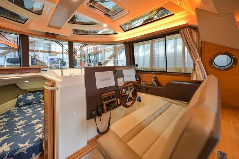 Celtic Mist Yacht Photos Pics 2023 Ranger Tugs R-29S interior with helm, navigation equipment, and cozy cabin.