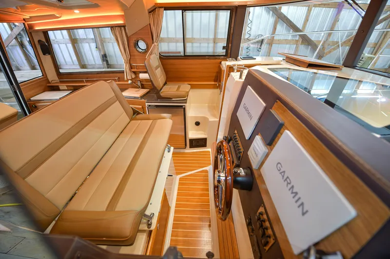 Celtic Mist Yacht Photos Pics 2023 Ranger Tugs R-29S interior with Garmin navigation, wood accents, and beige seating.