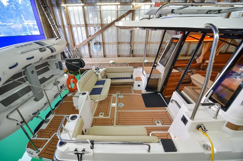 Celtic Mist Yacht Photos Pics 2023 Ranger Tugs R-29S boat interior with seating and wooden deck in a marina setting.