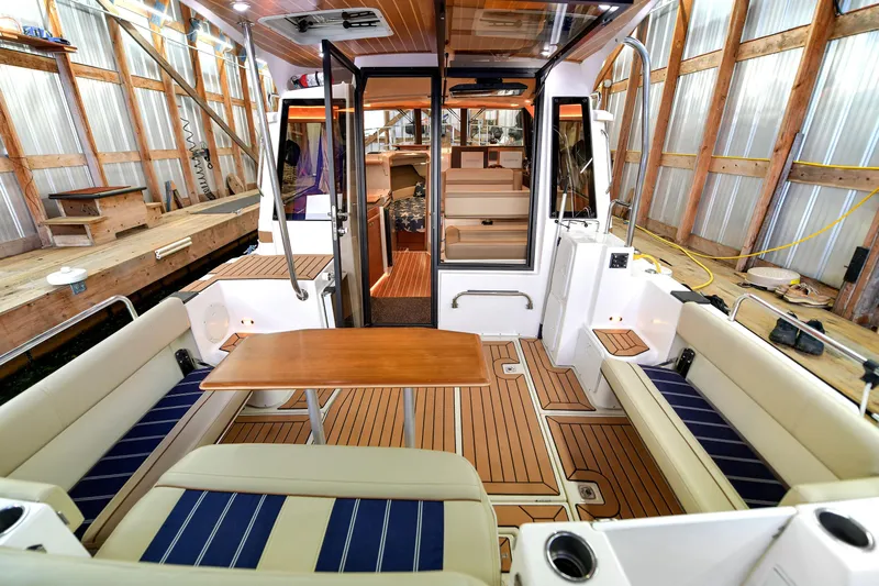 Celtic Mist Yacht Photos Pics 2023 Ranger Tugs R-29S boat interior with seating and wooden table in a dock setting.