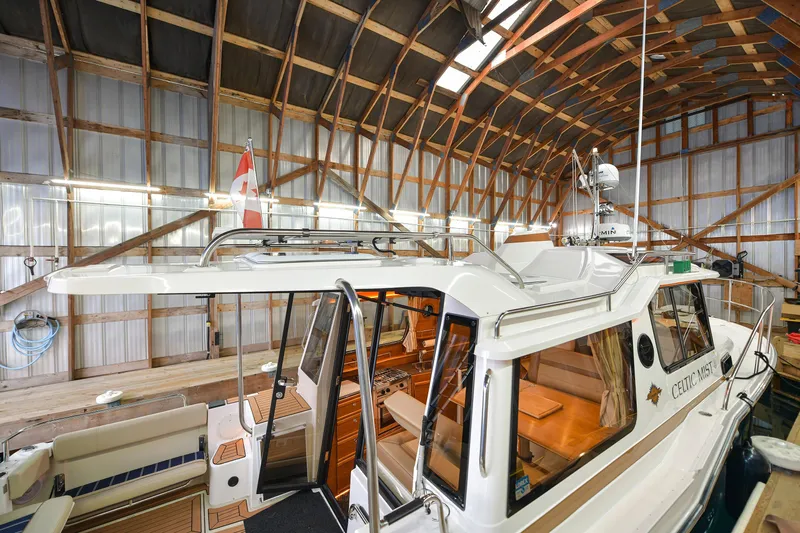 Celtic Mist Yacht Photos Pics 2023 Ranger Tugs R-29S boat docked in a wooden boathouse.