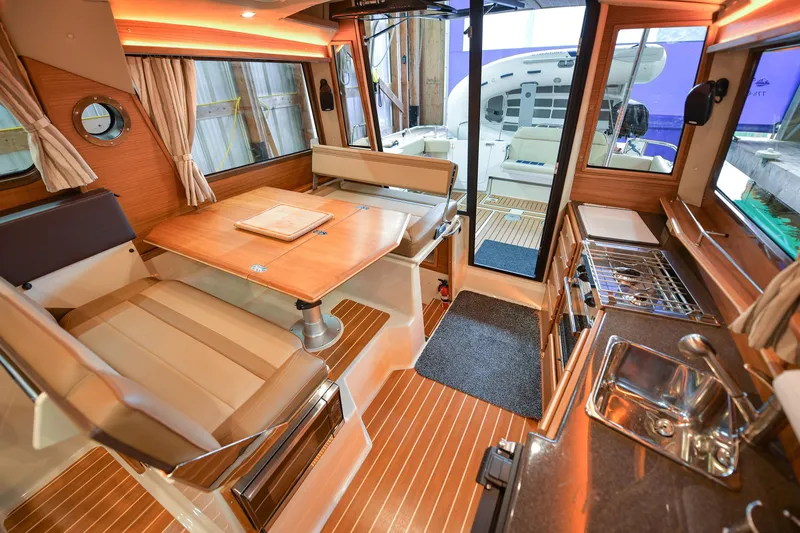 Celtic Mist Yacht Photos Pics 2023 Ranger Tugs R-29S interior with dining area, kitchenette, and wood accents.