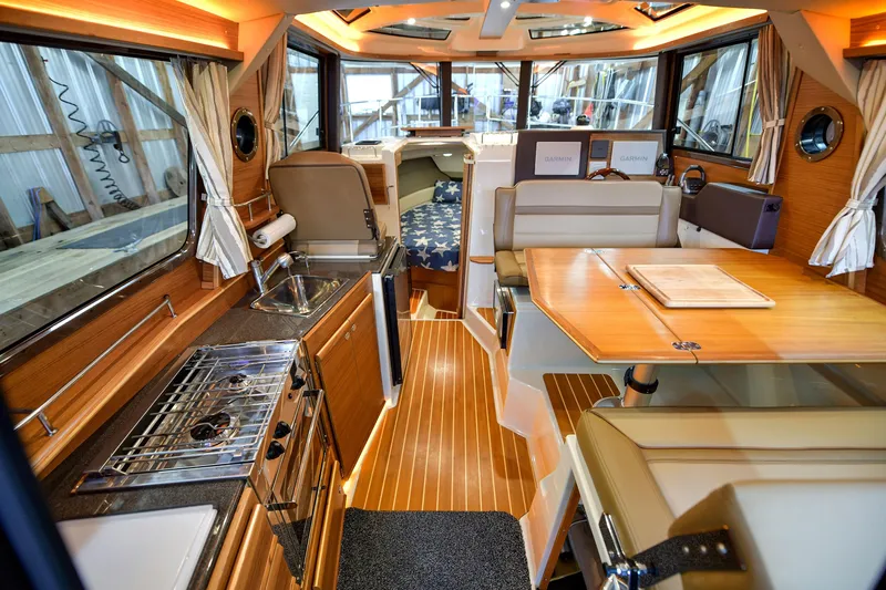 Celtic Mist Yacht Photos Pics Interior of 2023 Ranger Tugs R-29S, featuring kitchen, dining area, and helm station.