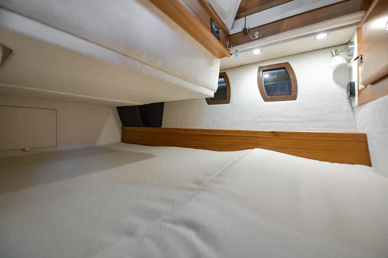Celtic Mist Yacht Photos Pics 2023 Ranger Tugs R-29S cabin interior with cozy bed and porthole windows.