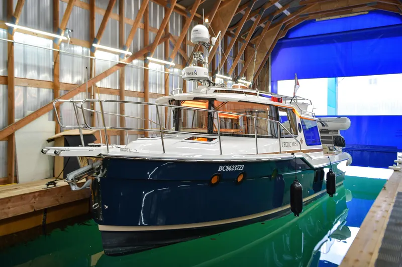 Celtic Mist Yacht Photos Pics 2023 Ranger Tugs R-29S boat docked in a wooden boathouse.