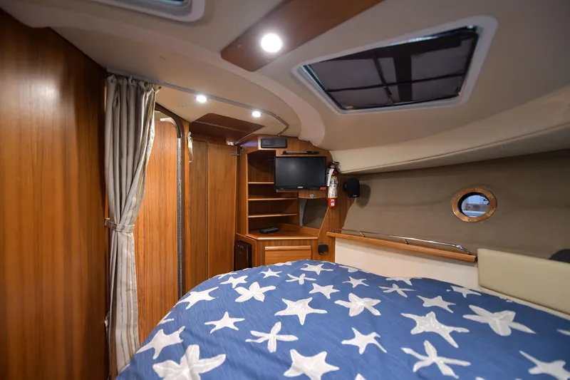 Celtic Mist Yacht Photos Pics 2023 Ranger Tugs R-29S cabin interior with star-patterned bedding and wooden finishes.