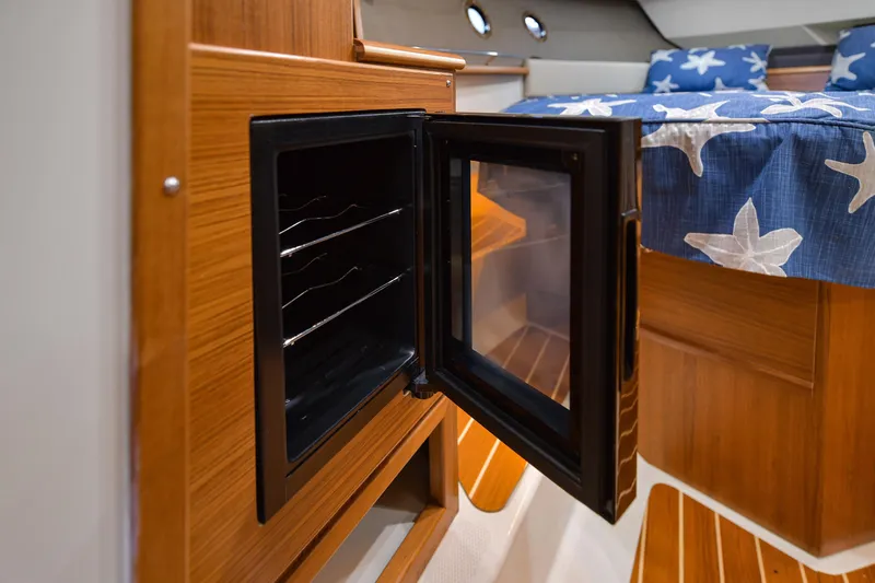 Celtic Mist Yacht Photos Pics 2023 Ranger Tugs R-29S interior with open mini fridge and starfish-patterned bedding.