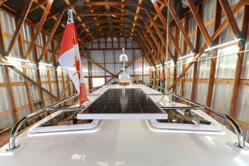 Celtic Mist Yacht Photos Pics 2023 Ranger Tugs R-29S in a wooden boathouse with solar panel and flag.