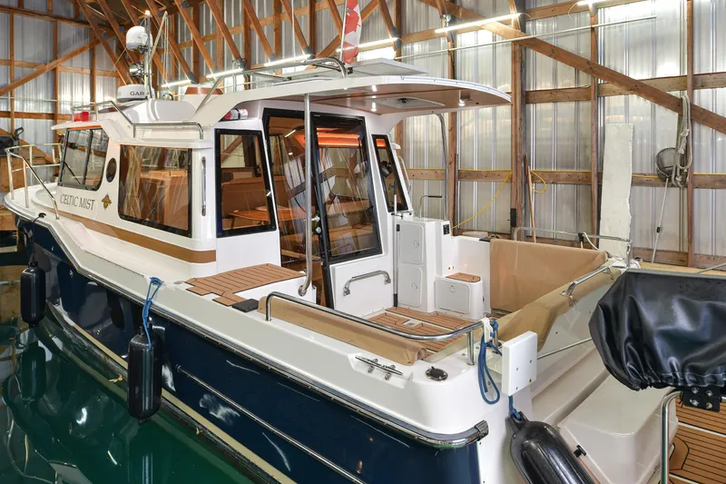 Celtic Mist Yacht Photos Pics 2023 Ranger Tugs R-29S boat docked in a wooden boathouse, featuring a spacious deck.