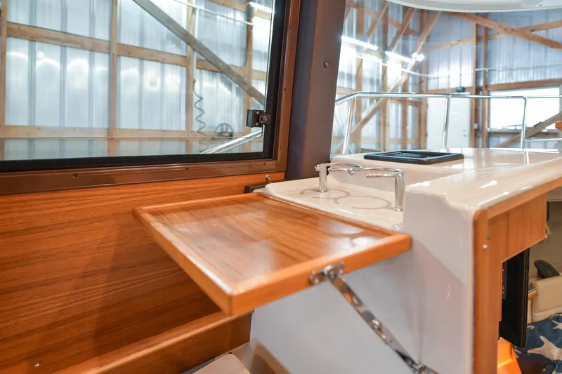Celtic Mist Yacht Photos Pics 2023 Ranger Tugs R-29S interior with wooden fold-out table and window view.