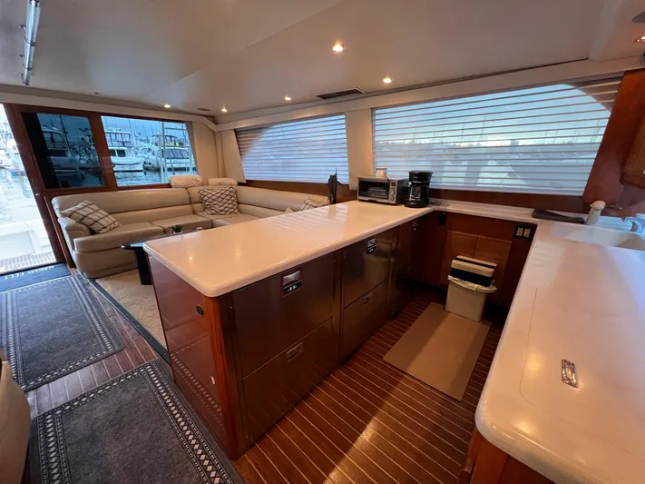 Todo Bien Yacht Photos Pics Luxurious interior of a 2000 Viking 58 Enclosed Bridge yacht with modern kitchen and seating area.