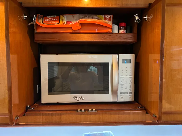 Todo Bien Yacht Photos Pics Microwave in wooden cabinet on 2000 Viking 58 Enclosed Bridge yacht kitchen.