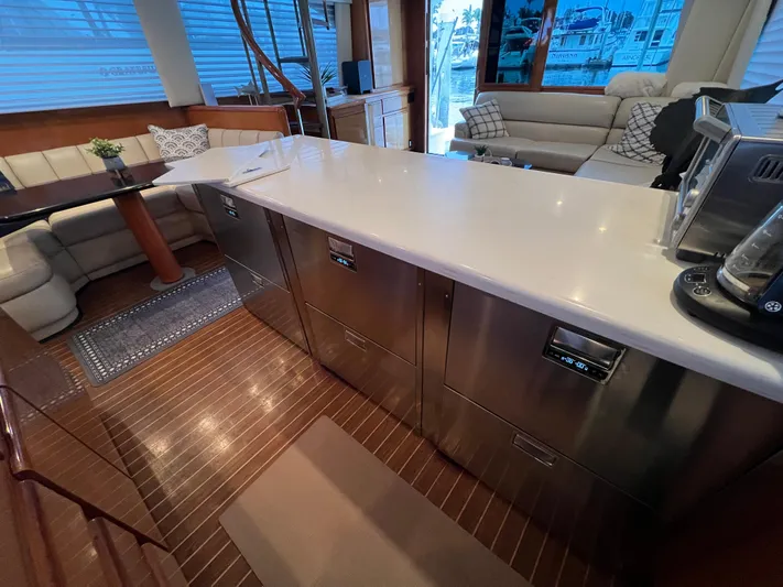 Todo Bien Yacht Photos Pics Luxurious interior of 2000 Viking 58 Enclosed Bridge yacht with modern kitchen and seating area.
